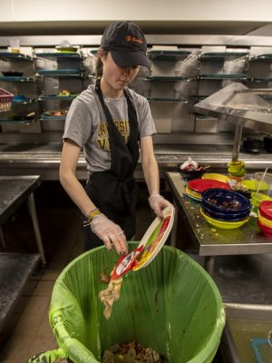 Sarah Anastasio cleans off a plate in the dining hall at Kimball Hall in the College of the Holy Cross.(Jesse Costa/WBUR)